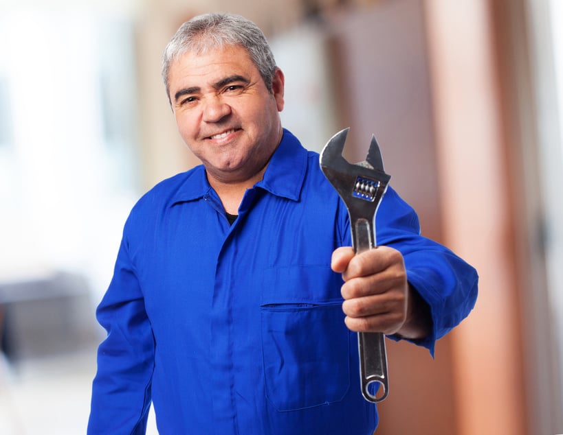 senior-man-with-blue-jumpsuit-holding-wrench